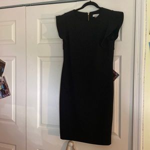 Black midi sheath dress with ruffle shoulders .